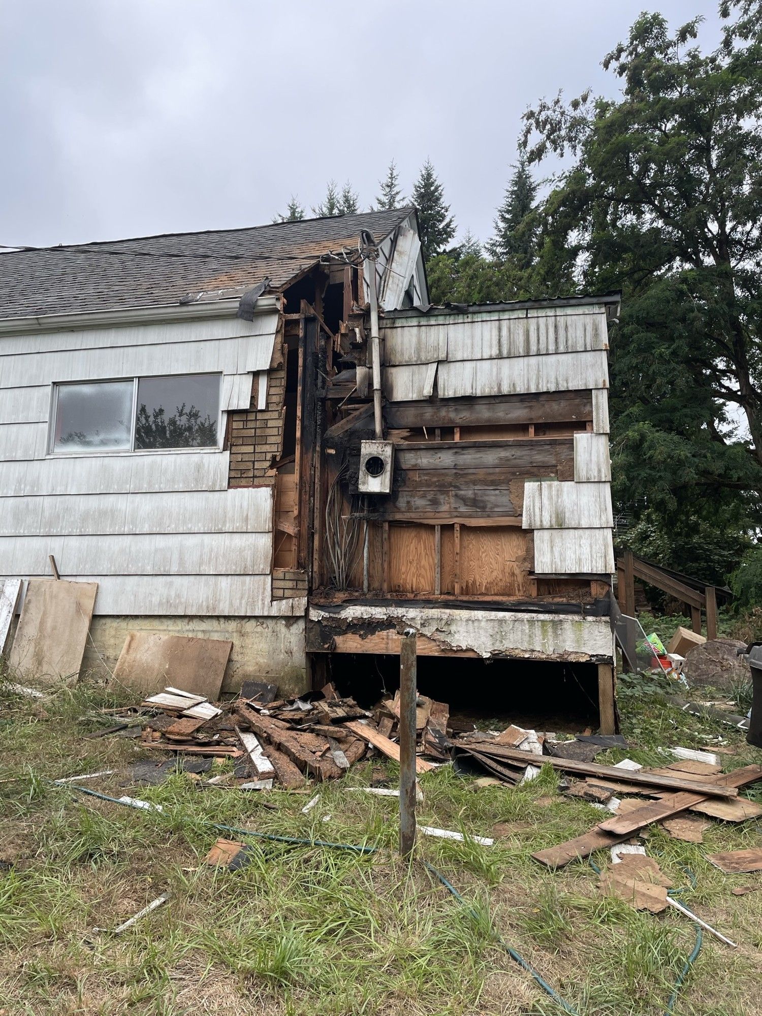 Fire-damaged exterior wall of a house during fire and smoke damage restoration in Chehalis, WA